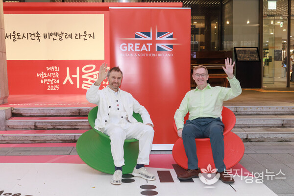 헤더윅이 디자인한 체험형 작품인 스펀 체어(Spun Chair)에서 포즈를 취한 주한영국대사 콜린 크룩스(Colin Crooks, 오른쪽)와 토마스 헤더윅(Thomas Heatherwick, 왼쪽))