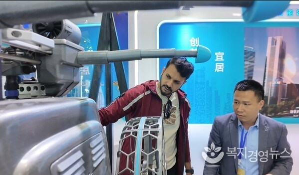 At an exhibition of the 2025 World Cities Day China Observance, a foreign visitor explored the robots and learned about their features and performance. (Photo/Luo Huxin)